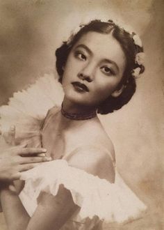 an old fashion photo of a woman in white dress holding a glass with her right hand