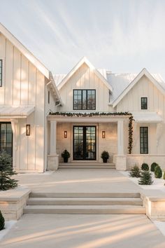 a white house with steps leading up to the front door and windows on each side