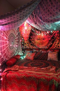 a bed covered in blankets and lights with a sun face on the wall above it