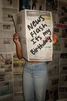 a woman holding up a newspaper with the words news flash it's my birthday written on it