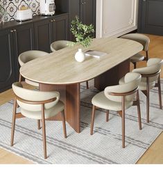 a dining table with six chairs and a vase on it in a living room area