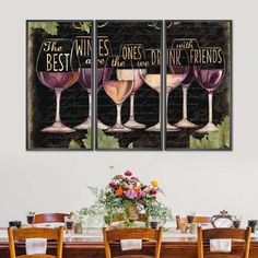 three wine glasses sitting on top of a wooden table next to a vase with flowers