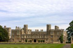 an old castle with a large lawn in front