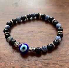 Our evil eye protection beaded bracelets are made with blue evil eye beads and a combination of black onyx and sodalite. Each bracelet is made with the intention to protect you from the evil eye and negative energies through each gemstone, and they're stretchy enough to fit a variety of wrist sizes. Please note that each bracelet is handcrafted for your order, so you will not receive the exact one pictured. ----------------------------------------------------------------------------------------- Spiritual Black Evil Eye Bracelet With 8mm Beads, Black Spiritual Evil Eye Bracelet, Black Evil Eye Bracelet With Black Beads, Black Evil Eye Bracelet With Beads, Black Beaded Bracelet With Evil Eye, Black Spiritual Evil Eye Bracelet With Round Beads, Spiritual Black Evil Eye Bracelet With Round Beads, Black Evil Eye Bracelet Spiritual Style, Protection Bracelet Spiritual