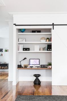 a room with a desk and shelves in it