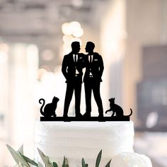 a wedding cake topper with two people and a cat on the bottom is shown