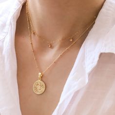 This Zodiac Necklace is a gold pendant necklace you will adore! You can choose your zodiac sign or your loved one's - how cute is that! Layer with other necklaces or wear it as statement jewelry. Coin size: 18 mm, thickness: 2 mm Spring ring clasp (6mm) 18K gold plated coin 14K gold filled chain (Cable, Figaro or Satellite) Comes with 2" extender Nickel-free Dainty Zodiac Sign Pendant Necklace, Gold Plated Zodiac Sign Round Necklaces, Dainty Zodiac Sign Round Necklace, Dainty Zodiac Sign Necklace, Gold Celestial Charm Necklace With Zodiac Sign, Celestial Style Gold Charm Necklace With Zodiac Sign, Gold Celestial Zodiac Sign Charm Necklace, Celestial Style Gold Zodiac Sign Charm Necklace, Gold Dainty Zodiac Sign Jewelry