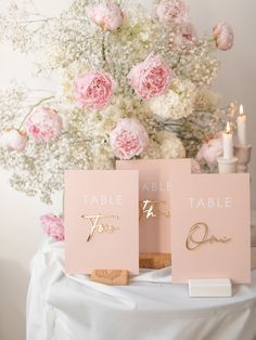 two place cards with the word table to be placed on top of each other in front of a bouquet of flowers