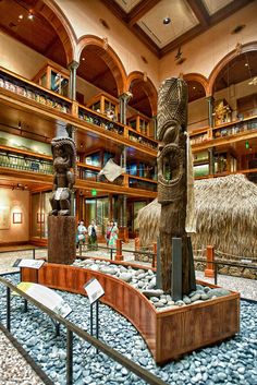 the inside of a museum with statues and bookshelves