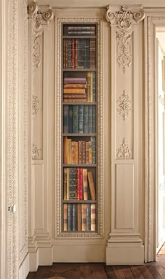 a book shelf with many books on it in the middle of a room filled with wooden floors