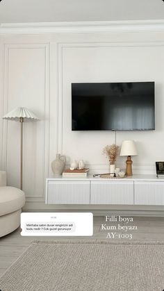 a white living room with a flat screen tv on the wall