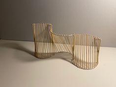 two wooden sculptures sitting on top of a white table next to each other and one is made out of wood sticks