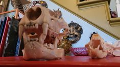 a close up of a fake animal skull on a red table next to some books