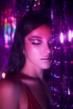 a woman in a red dress with purple lights behind her