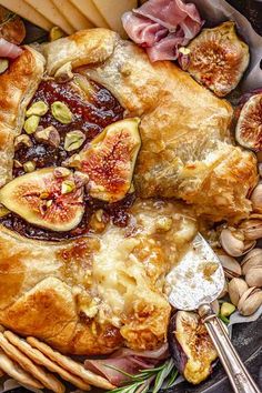 an assortment of food on a platter including figs, nuts and bread