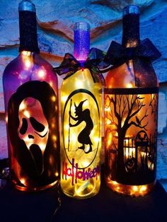 three bottles decorated with halloween decorations and lights