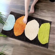 a person standing on the floor with their feet in front of an area rug that has circles