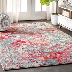 an area rug with various colors and patterns on the floor in front of a window