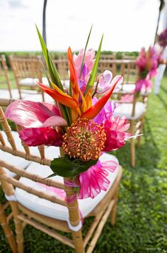 an arrangement of flowers is on the back of chairs