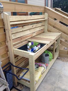 a bench made out of wooden pallets with plants growing in the bottom shelf and potted plants on top