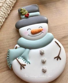 a snowman cookie sitting on top of a wooden table