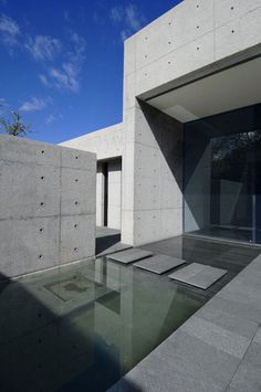 an empty room with concrete walls and flooring next to a glass door on the outside