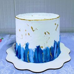 a white cake with blue and gold icing