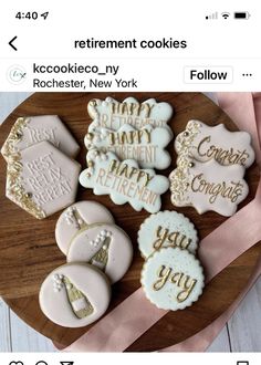 some cookies that are sitting on a wooden platter with pink and gold ribbon around them