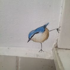 a bird painted on the side of a wall with a stick in it's mouth