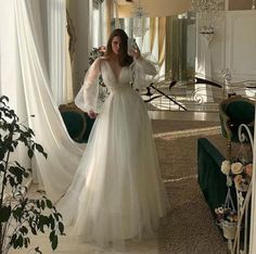 a woman standing in front of a mirror wearing a white dress and holding her hair