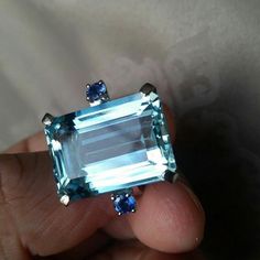 Specification:- Stone Details :-  *Diamond Material : Cubic Zirconia (CZ) *Center Diamond Shape : Emerald Cut *Total Diamond Weight : 5.33 CT (Approx.) *Center Diamond Dimension : 11*9 MM  *Center Diamond Weight : 5.21 CT *Side Diamond Dimension : 2.40 MM  *Side Diamond Weight : 0.12 CT *Diamond Color : Blue, Aquablue *Clarity : VVS *Making Process: Handmade by our Experienced Staff. *Stamp: Our All Rings Stamped According to metal Purity (925 SIL/10K/14K/18K). Procedure information Please selec Emerald Cut Light Blue Jewelry For Weddings, Light Blue Emerald Cut Wedding Jewelry, Light Blue Emerald Cut Jewelry For Wedding, Blue Diamond Crystal Ring Gift, Light Blue Brilliant Cut Topaz Ring For Gift, Light Blue Brilliant Cut Topaz Ring As Gift, Light Blue Brilliant Cut Topaz Ring Gift, Light Blue Sapphire Ring With Center Stone For Wedding, Light Blue Emerald-cut Topaz Ring For Gift