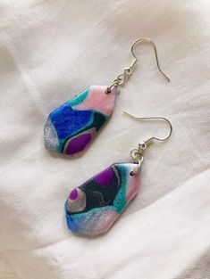 What is this product?  This is a limited edition, handmade pair of earrings. The abstract pattern effect is hand-developed using polymer clay.  Due to the shimmery pearlescent nature of the earrings, you will notice subtle changes in color (like a holographic effect) depending on how the light hits them :) A gorgeous effect indeed!  The pair goes well with summer dresses, office wear and many other casual and formal looks. They are so lightweight that you'll forget you have them on! :) What is it made of?  These earrings are made using highest quality polymer clay. The Ear Wire is made of stainless steel, making the earrings non-allergic.  Care Instructions:  1. Always store the earrings in a dust-free environment, preferably in boxes lined with soft fabric or cotton.  2. Never use abrasiv Multicolor Polymer Clay Drop Earrings, Multicolor Resin Earrings, Multicolor Polymer Clay Earrings, Handmade Multicolor Resin Earrings, Artistic Multicolor Resin Earrings, Multicolor Hypoallergenic Polymer Clay Jewelry, Hypoallergenic Multicolor Polymer Clay Jewelry, Multicolor Resin Drop Earrings, Multicolor Resin Teardrop Earrings