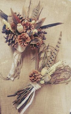 an arrangement of dried flowers and feathers on a piece of cloth