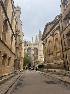 an empty street with people walking on the side and buildings in the backgroud