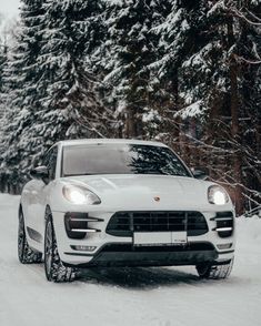 a white porsche cayen driving down a snow covered road