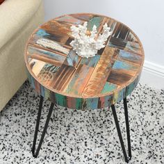 a wooden table sitting on top of a black and white floor next to a couch