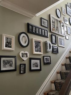 a staircase with many pictures and frames on the wall