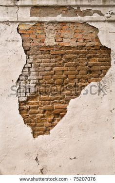 an old brick wall that has been torn down with the paint chipping off it