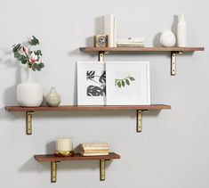 two wooden shelves with books and vases on them