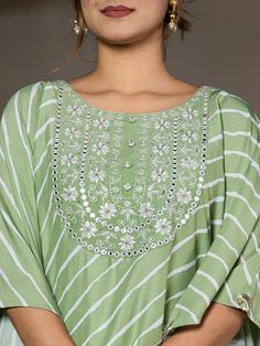 This 2-piece set includes green embroidery & leheriya print kaftan style kurta has round neck, short flared sleeves, flared hem, calf length teamed with solid trouser pants with elasticated waistband & slip on closure. 2 Piece Set Color-Green Kurta Fabric- Silk Blend Work - Thread Work Embroidery & Leheriya Print Detailing Neck - Round Neck Sleeves - Short Flared Sleeves Length-Calf Length Pocket - Single Pocket Bottom - Solid Trouser Pants Size & Fit - Elasticated Waistband Bottom - Slip-on Closure Washing Care-Hand Wash The model height 5'8 is wearing a size small Green Traditional Wear With Gota Work For Spring, Spring Green Traditional Wear With Gota Work, Spring Green Embroidered Palazzo Set, Spring Festive Green Palazzo Set, Spring Salwar Kameez With Gota Work And Long Sleeves, Spring Anarkali Set With Mirror Work And Straight Kurta, Bollywood Style Kurta With Gota Work For Spring, Spring Pista Green Kurta With Mirror Work, Spring Long Sleeve Salwar Kameez With Gota Work