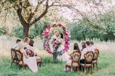 a man standing in front of a group of people with flowers around him and holding a bouquet