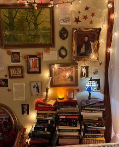 a room filled with lots of books and pictures on the wall next to a lamp