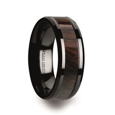 a black ceramic ring with wood inlays on the side and an inscription that reads,