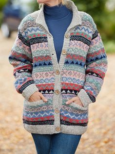 a woman wearing a multicolored cardigan sweater and jeans, with her hands in her pockets