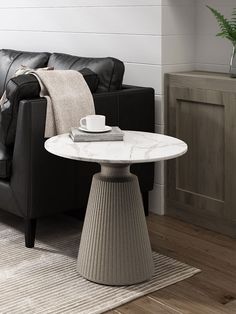 a living room with a black couch and white table in it's centerpiece