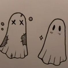 two cartoon ghost faces are drawn on a piece of paper