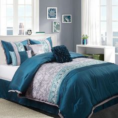 a bed with blue comforters and pillows in a room