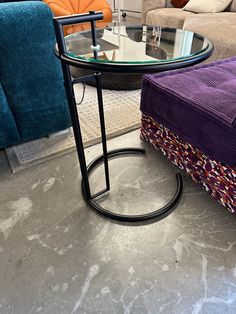 a living room filled with furniture and a glass top table in the middle of it