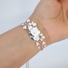 These Beautiful Romantic Bridal Bracelet porcelain White Flower Opal Bracelet are made of very fine quality of Porcelain white flowers and Natural Pearl Gemstone for your special day! Freshwater pearls are real, cultured pearls, grown in lakes, rivers, as well as ponds. Most Freshwater pearls are white and resemble Akoya pearls, but they also produce a variety of pastel shades, including pink, lilac and peach. Even we have hard time taking pictures because of their shine 😄 so we want to shine o Adjustable White Jewelry With Flower Decoration, Delicate White Flower Bracelets, Delicate White Flower Shaped Beaded Bracelets, Delicate White Bracelet For Wedding, Delicate White Flower Beaded Bracelets, Delicate White Bangle Bracelet, White Wedding Jewelry With Bracelet Strap, White Bracelet Strap Jewelry For Wedding, Adjustable White Bracelet With Flower Decoration