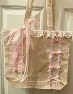 a pink and white bag hanging on a door handle with lace trimming around it